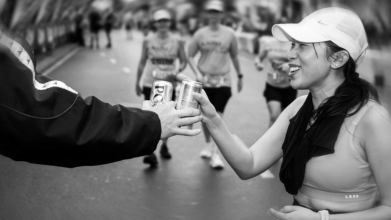 Australian runner at end of CityBay fun run in winter with a can of Posca Hydrate - winter hydration