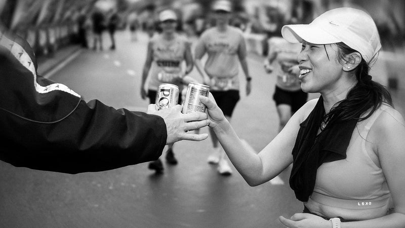Australian runner at end of CityBay fun run in winter with a can of Posca Hydrate - winter hydration