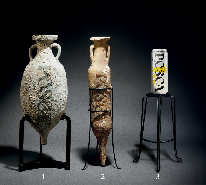 Two ancient ceramic vases on stands with a POSCA can for scale.