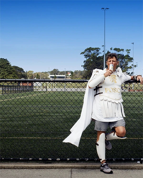 Comedian Merrick Watts dressed as a Roman Gladiator drinking a Posca Hydrate
